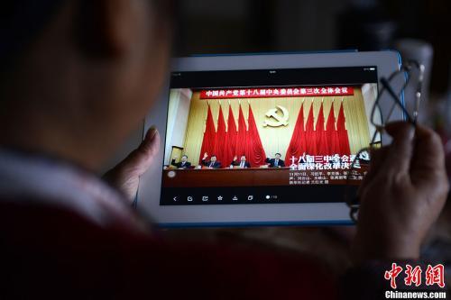 資料圖：一位網(wǎng)友用平板電腦瀏覽有關(guān)中國共產(chǎn)黨十八屆三中全會的報(bào)道。<a target='_blank'  data-cke-saved- >中新社</a>發(fā) 張浪 攝